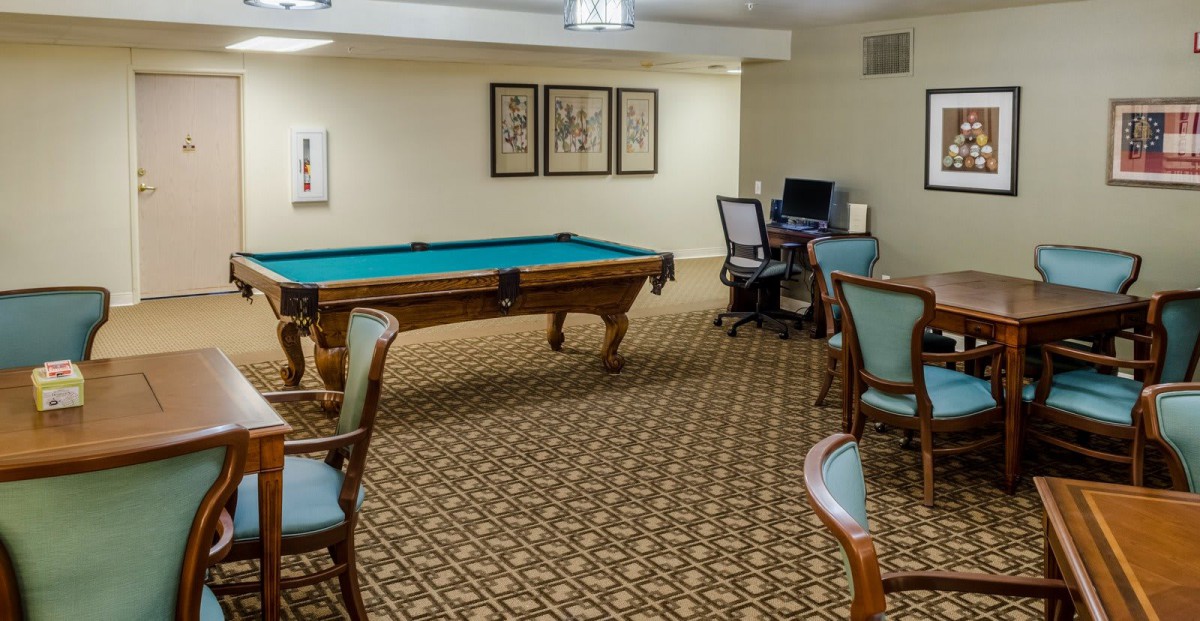 A cozy game room featuring a pool table and a computer desk setup.