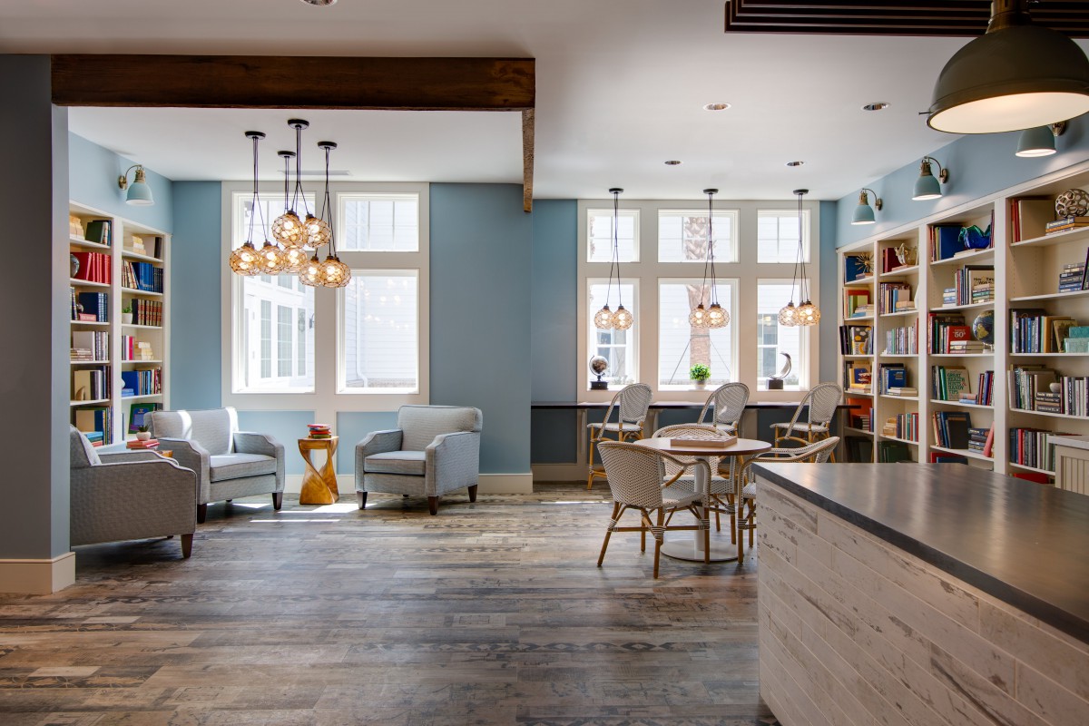 A modern living room with comfortable seating, ample natural light, and a stylish chandelier.