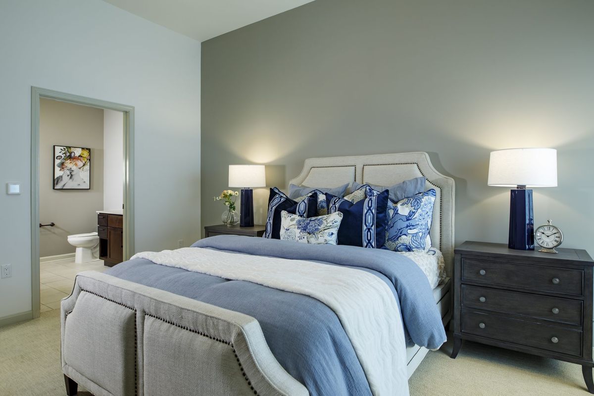 Elegant bedroom with a neatly made bed and stylish decor.