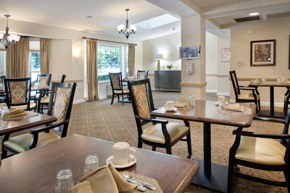 A well-lit dining area with neatly arranged tables and chairs, set against a tasteful interior design.