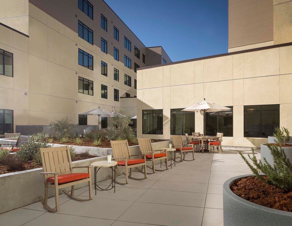 A modern patio area with tables and chairs in an urban setting.