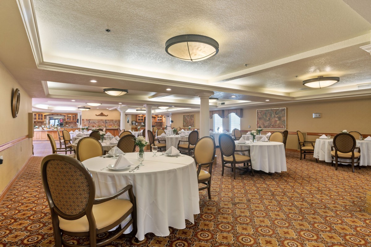 A well-decorated dining area with round tables and elegant chairs, ready for guests.
