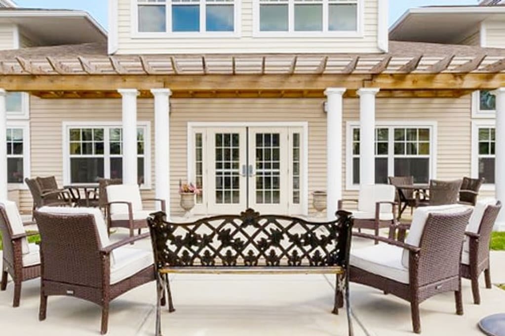 A stylish patio setup with ornate outdoor furniture and a classic pergola.