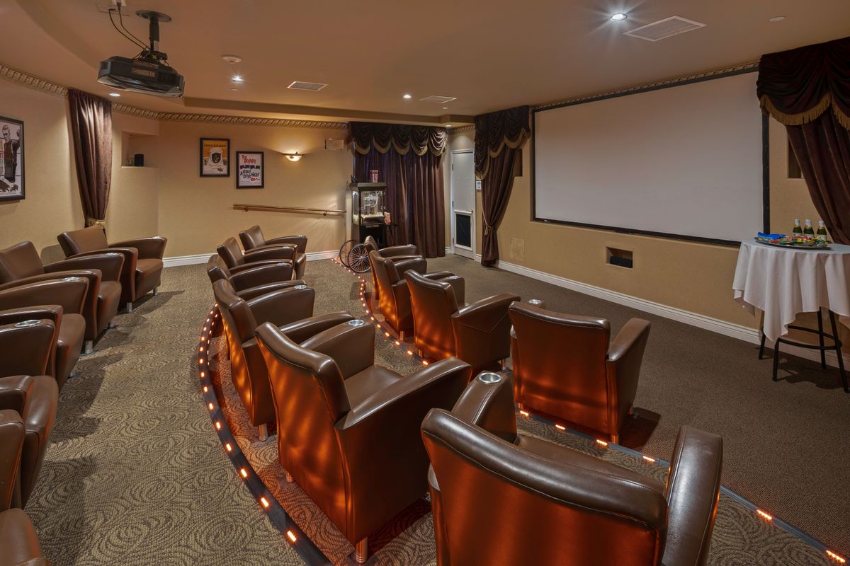 A cozy home theater with comfortable seating and a large projector screen.