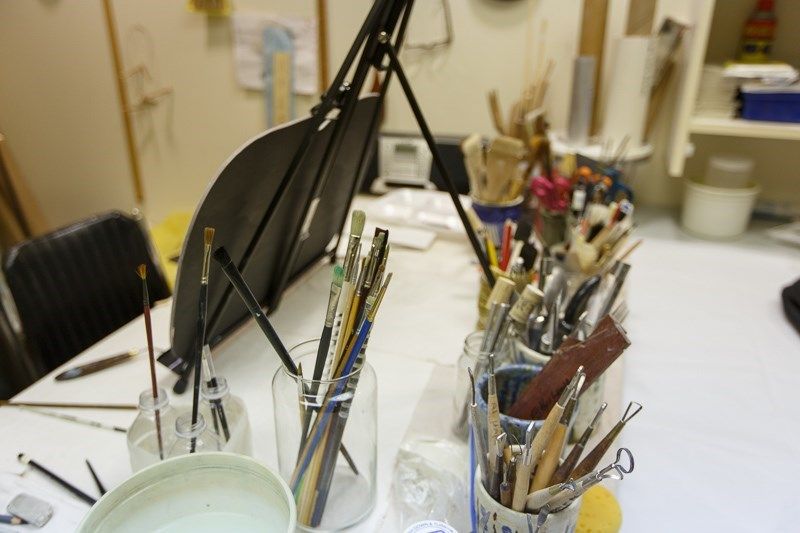 An art studio with brushes and painting supplies organized on a table, ready for creative work.