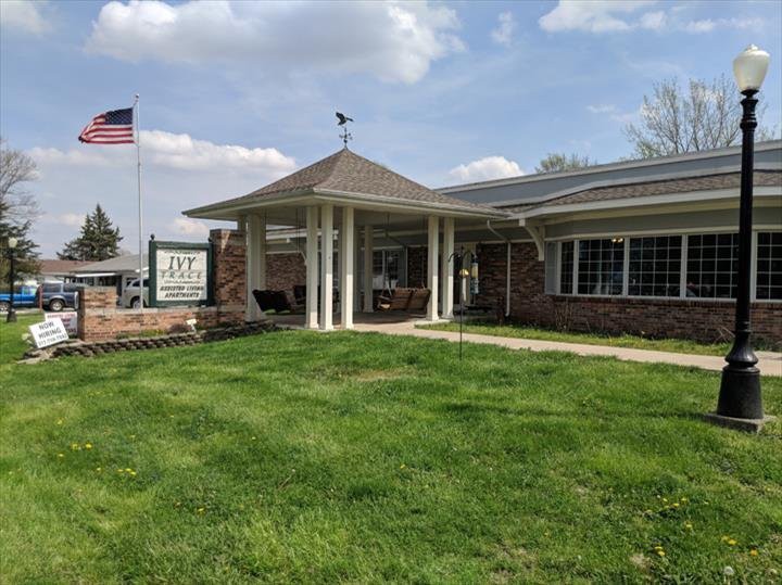A building with a grassy lawn and an American flag in front.