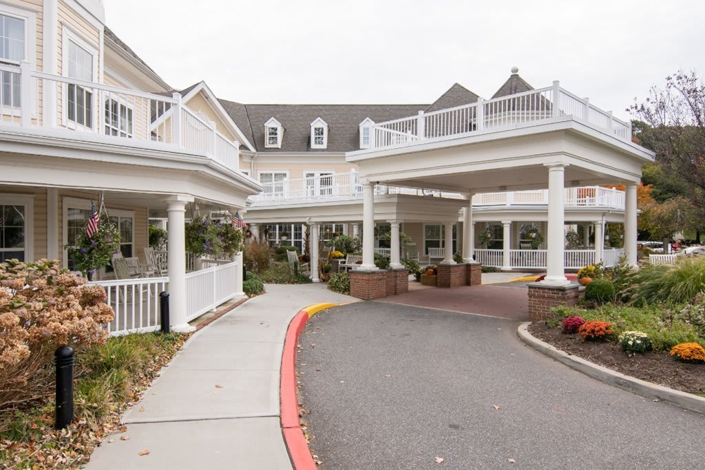 A large residential building with a covered entrance and driveway.
