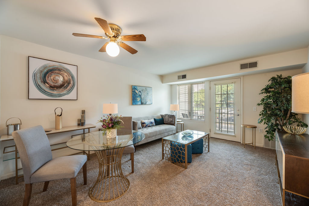 A cozy living room with a sofa, coffee table, dining area, and stylish dcor.