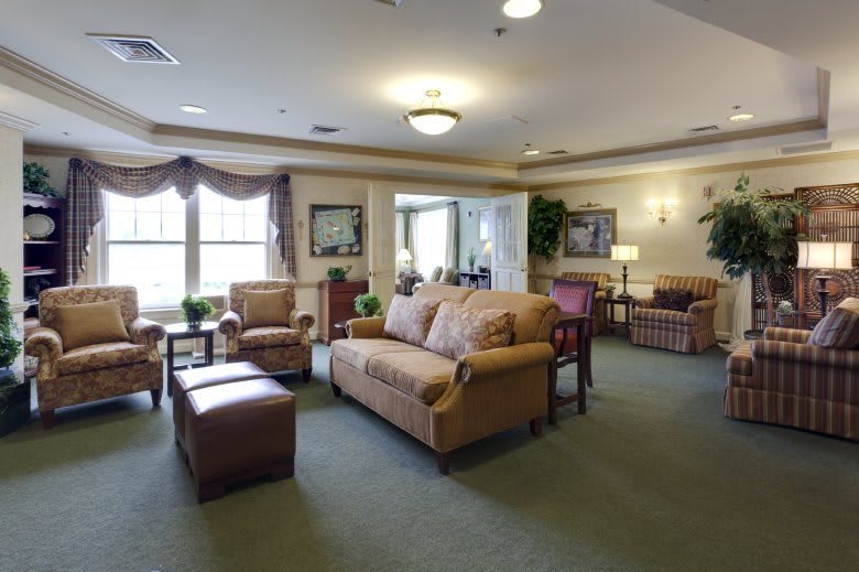 A comfortable and well-decorated living room area with sofas, chairs, and large windows.