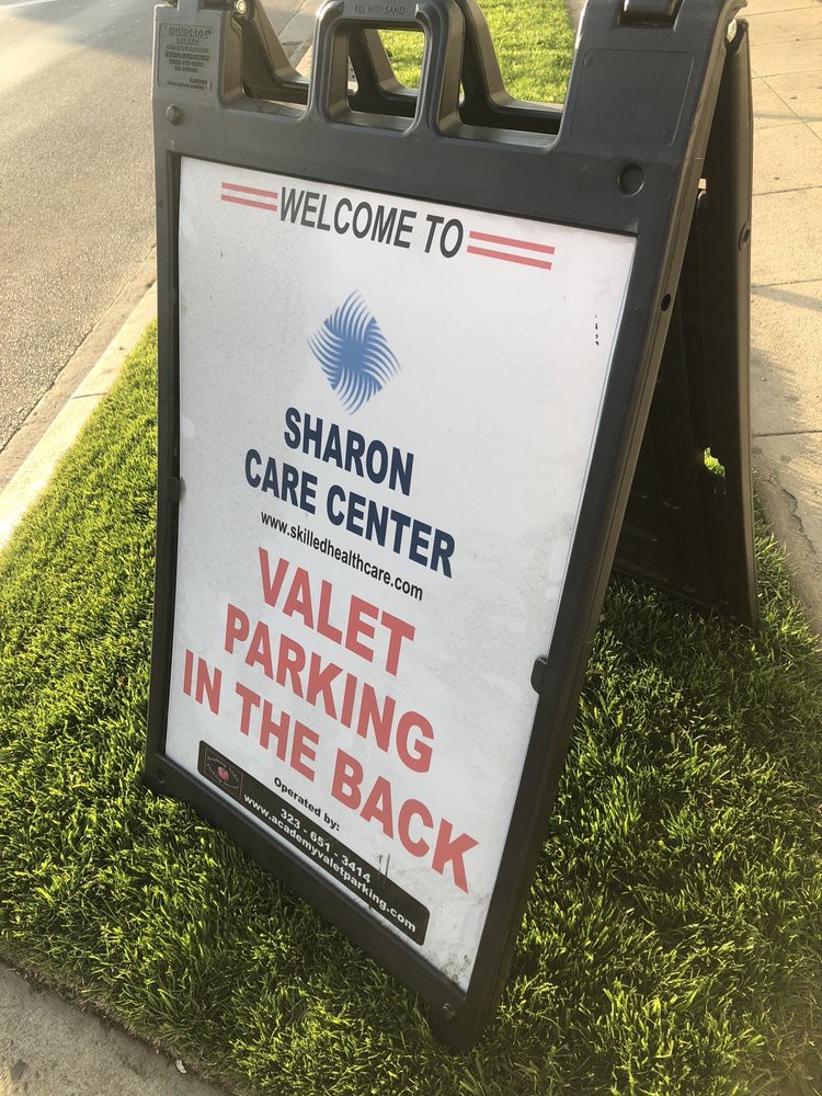 A sign for Sharon Care Center indicating that valet parking is available in the back.