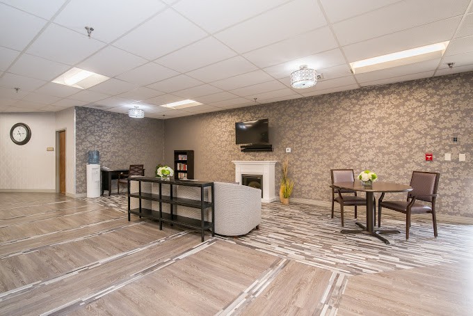 A modern lounge area featuring comfortable seating, a television mounted on a brick wall, and stylish decor.