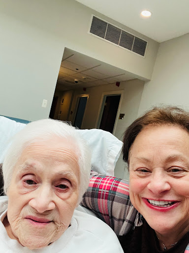 A joyful moment captured between a caregiver and an elderly woman.