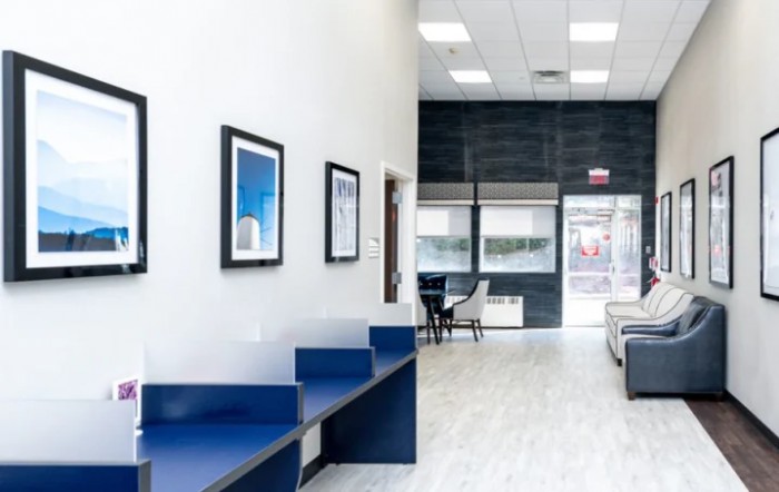 A modern office interior with seating and framed artwork on the walls.