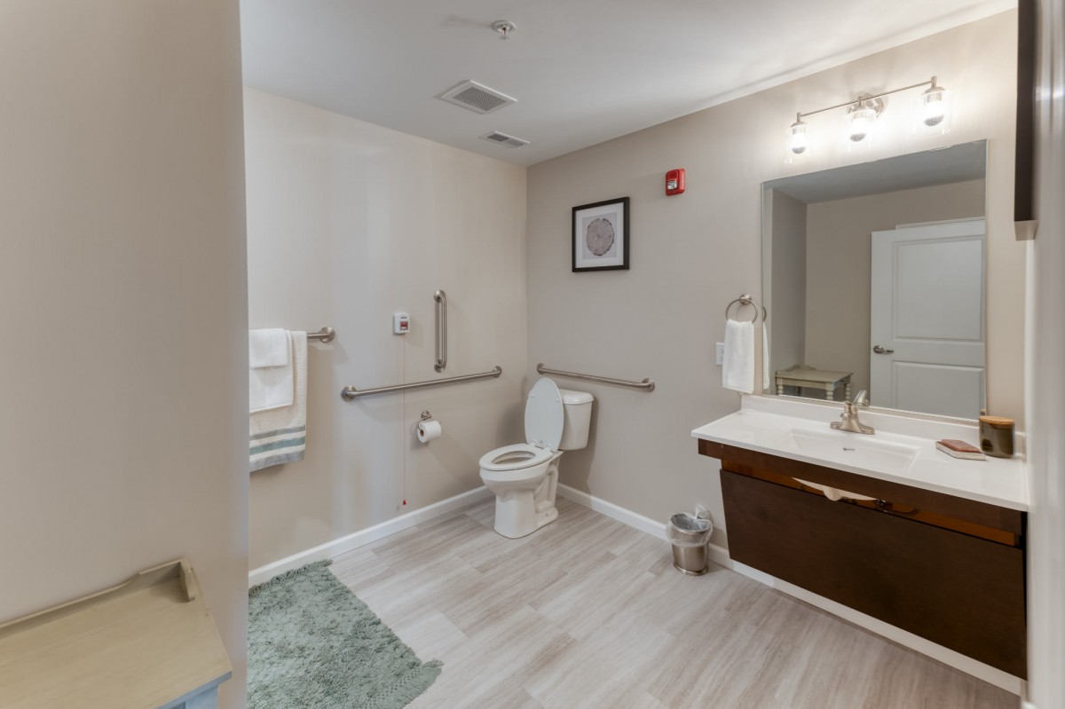 A modern, accessible bathroom with grab bars and a clean design.