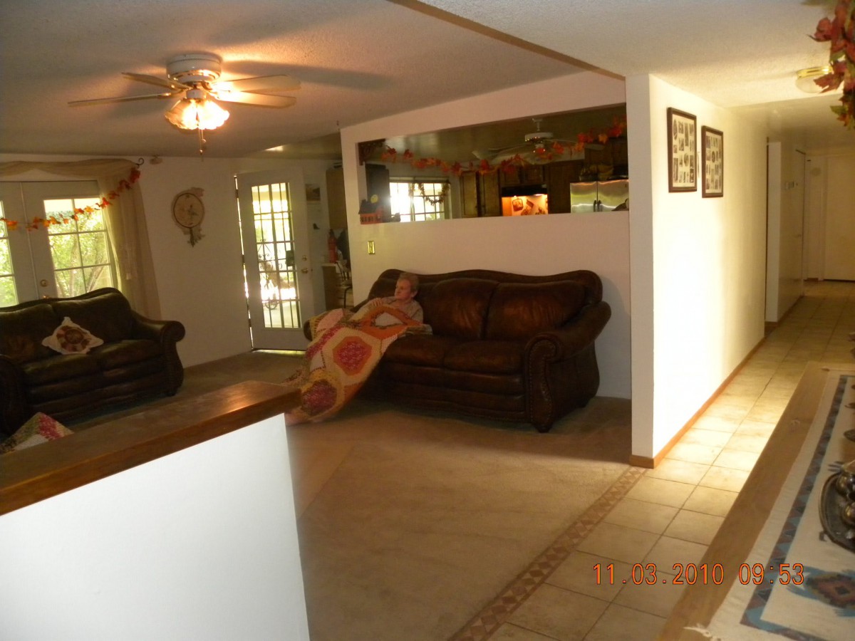 A cozy living room with a sofa, ceiling fan, and decorative elements.