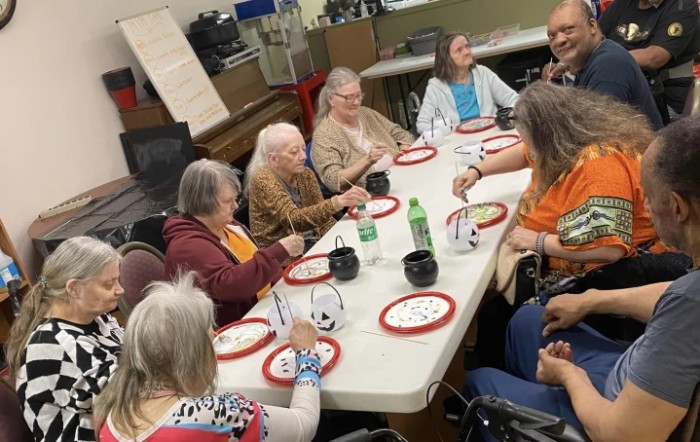 A group of people sitting around a table enjoying a meal together.