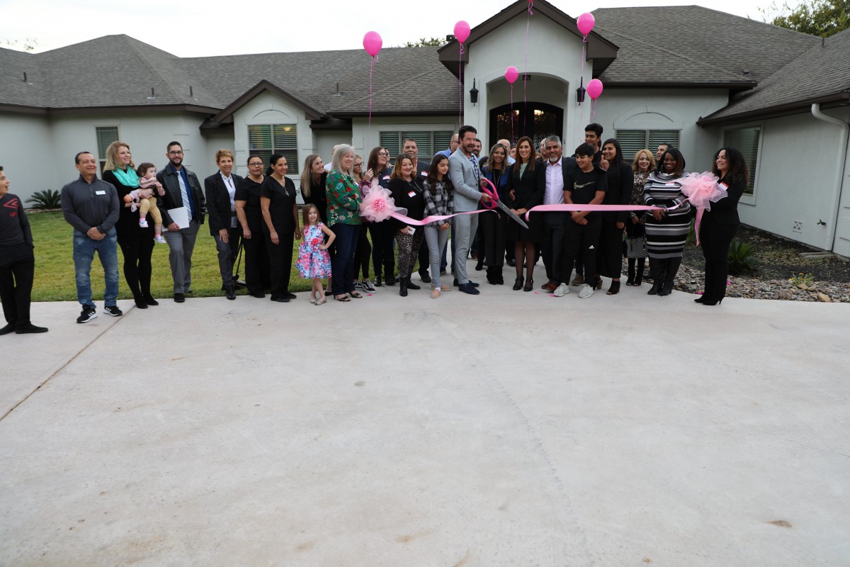 A group of people gathered in front of a building for a ribbon-cutting ceremony.