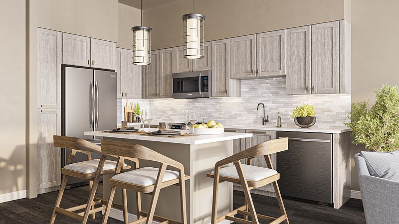 A modern kitchen featuring a central island with bar stools, stainless steel appliances, and pendant lighting.