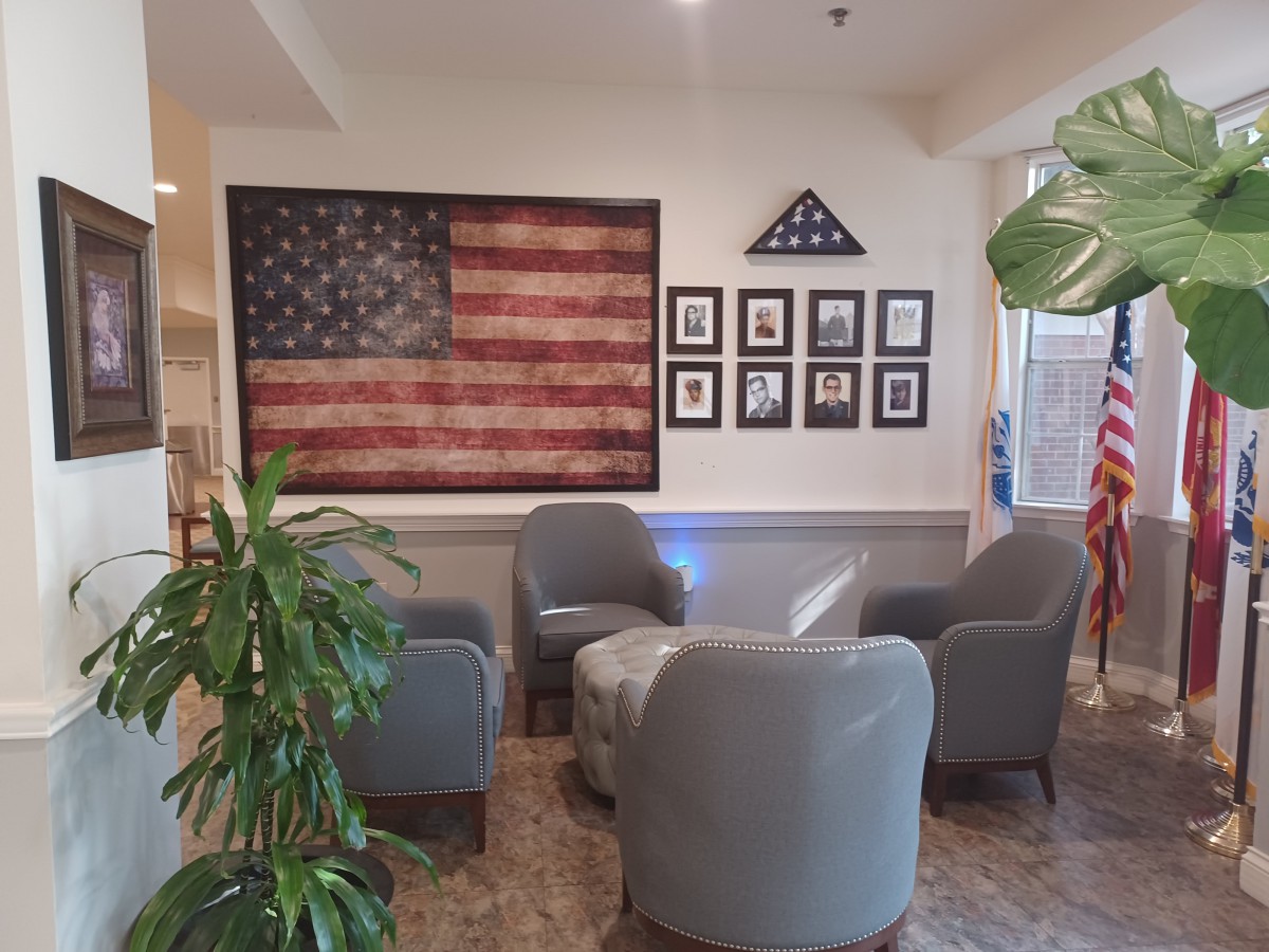 A cozy seating area adorned with an American flag and framed photos on the wall.