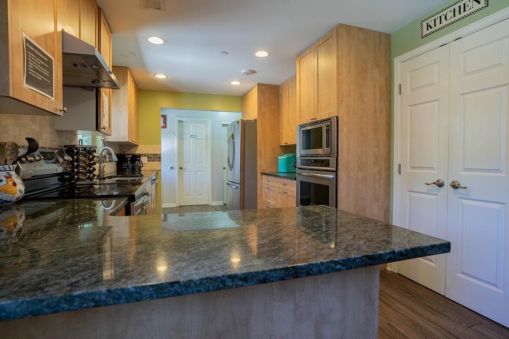 A modern kitchen with wooden cabinets, a sleek countertop, and stainless steel appliances.