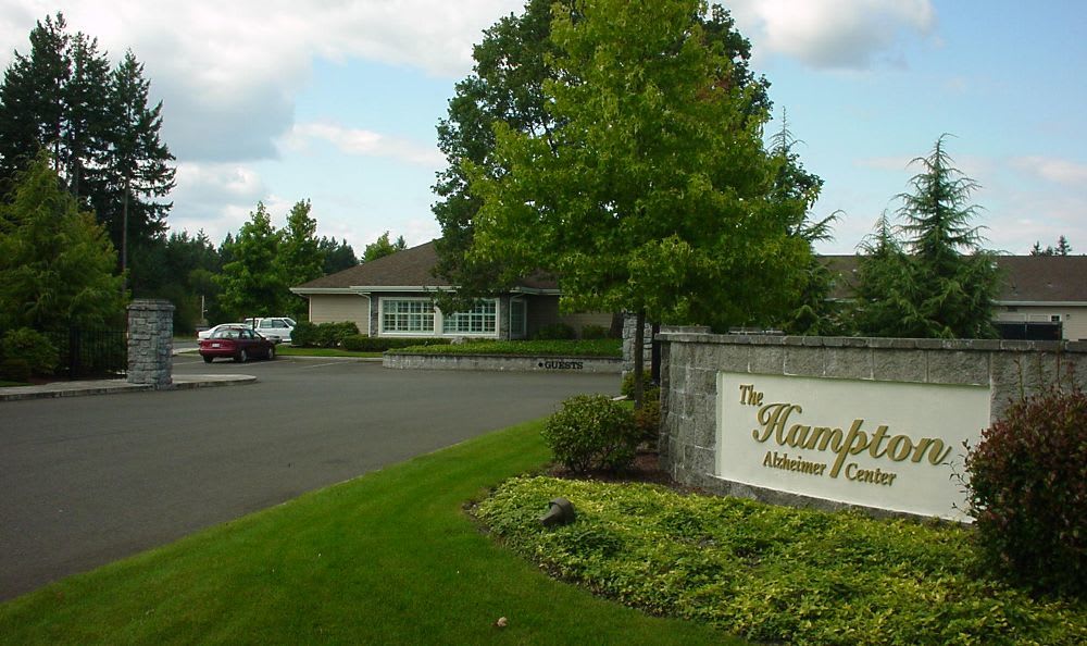 Entrance to a residential or community facility with green landscaping.