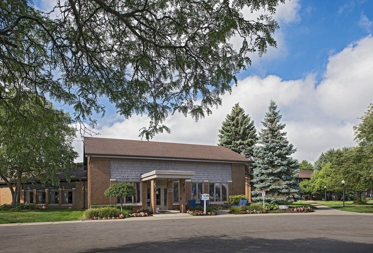 A small building surrounded by trees with a clear blue sky above.