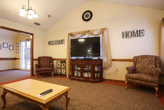 A cozy living room with a large TV, comfortable seating, and welcoming decor.