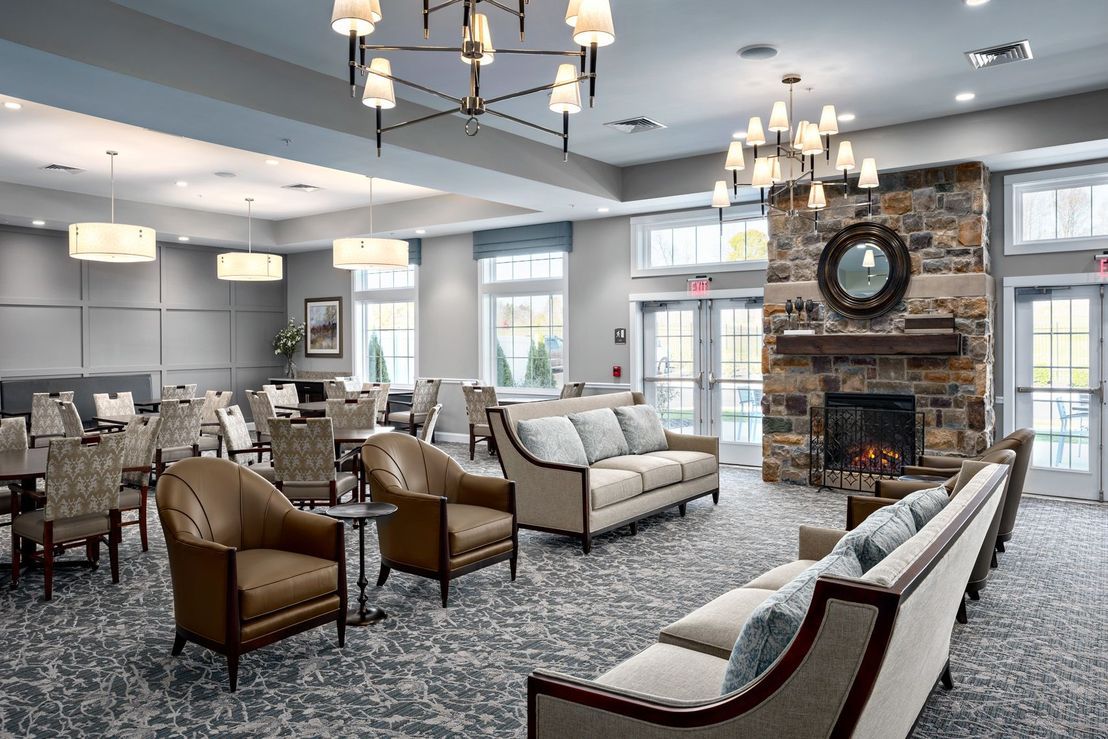 A spacious and elegantly decorated living room featuring comfortable seating, modern lighting, and a cozy fireplace.