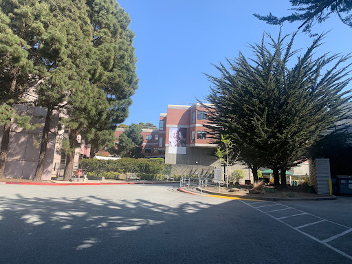 A peaceful scene featuring a building surrounded by trees under a clear blue sky.