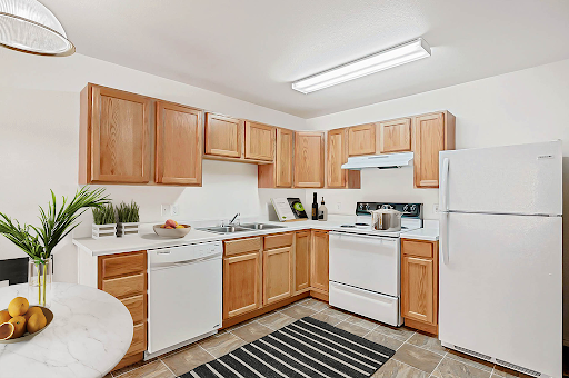 A cozy, modern kitchen featuring wooden cabinets and essential appliances.