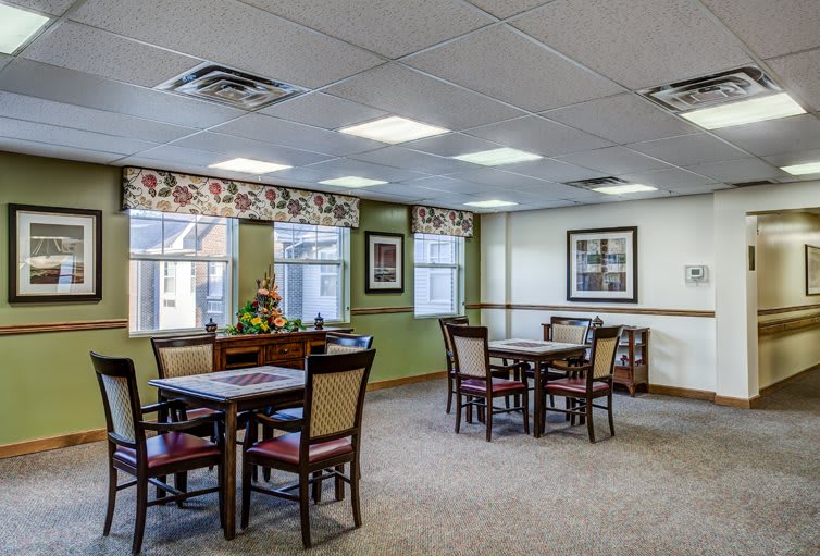 A cozy dining area with tables and chairs, featuring decorative elements and ambient lighting.