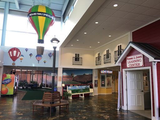 A vibrant indoor play area featuring a colorful hot air balloon and themed decorations, creating a fun environment for children.