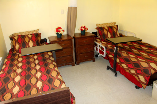A neatly arranged room with two beds, side tables, and decorative flowers.
