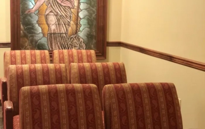 A row of upholstered chairs in front of a wall featuring a large framed painting.