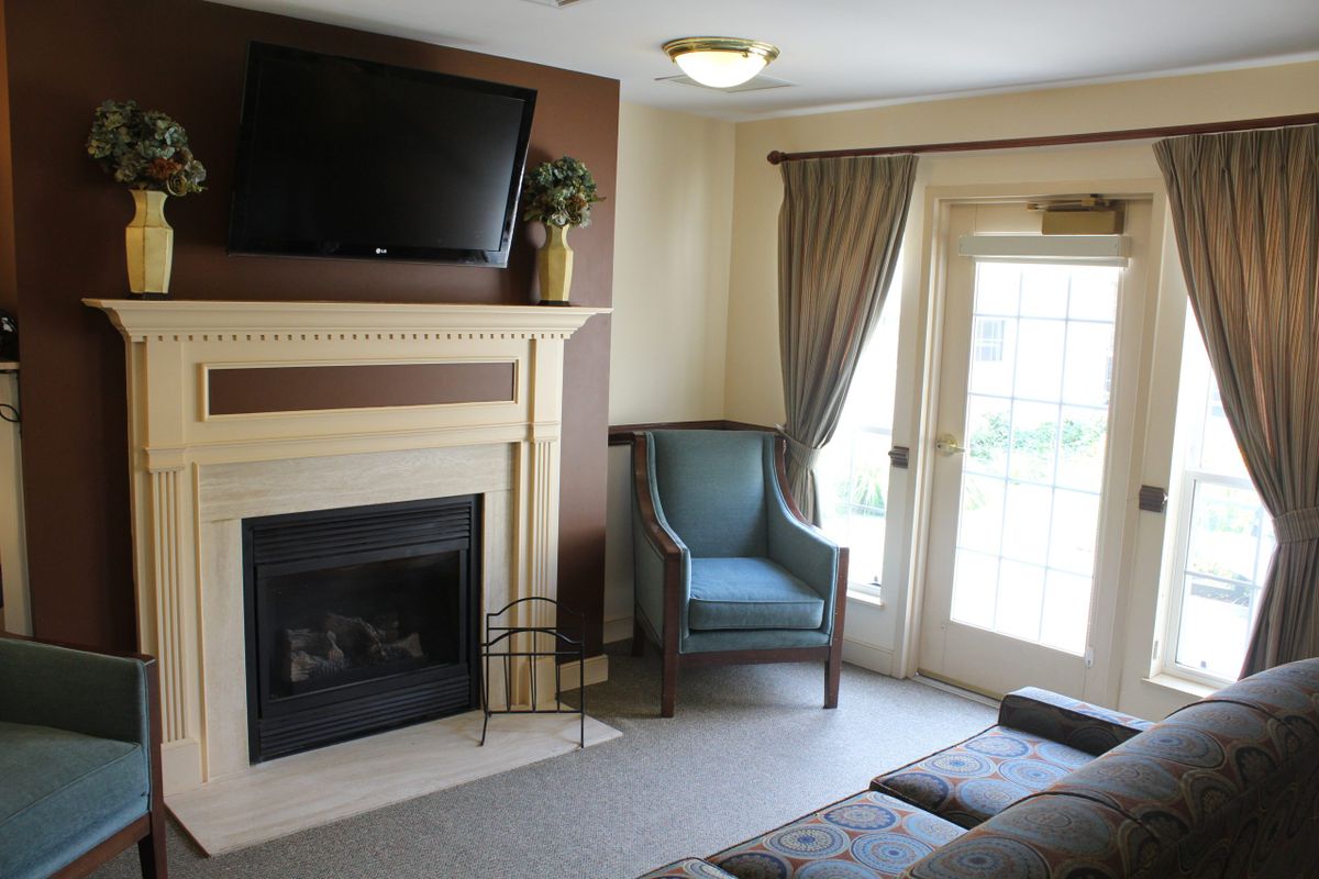 A cozy living room with a fireplace, television, and comfortable seating.