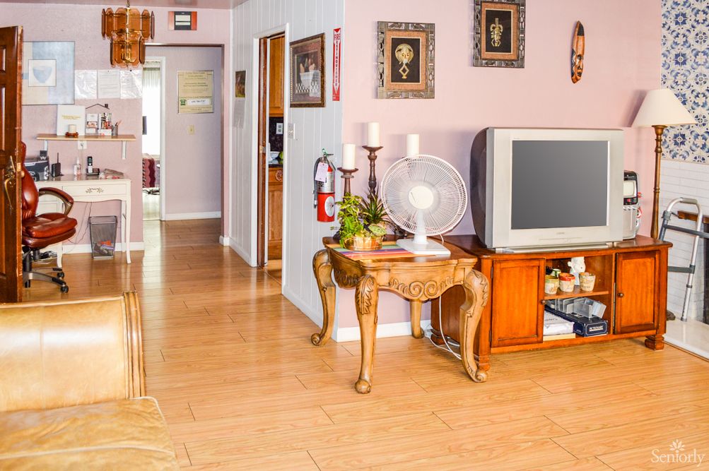 A cozy living room with vintage decor, featuring a wooden floor and a classic television set.
