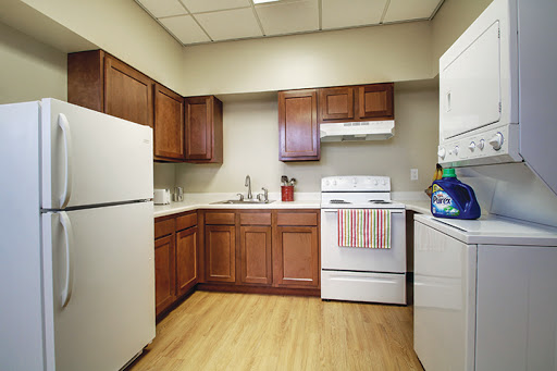 A modern kitchen featuring wooden cabinets, a refrigerator, and essential appliances.
