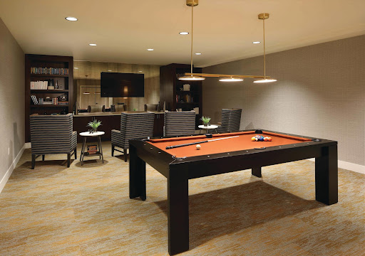 A stylish game room featuring a pool table and comfortable seating.
