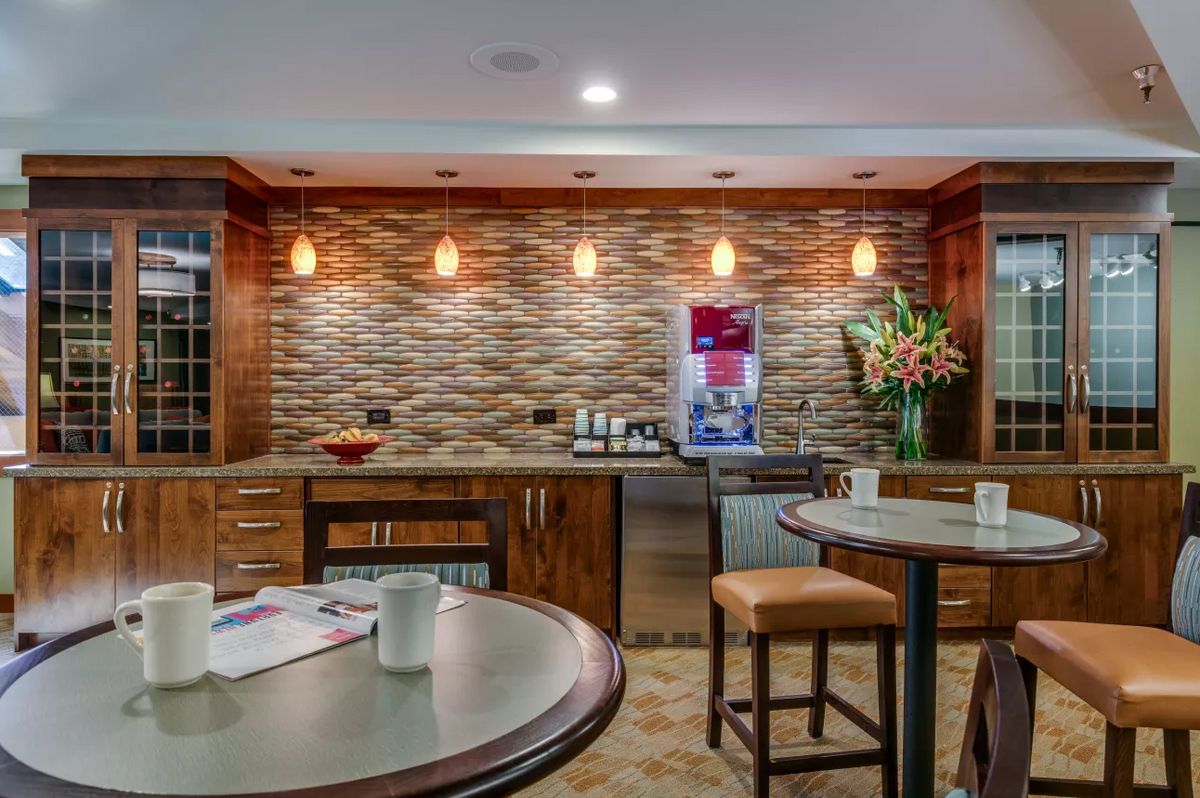A modern kitchen bar area with stylish lighting and wooden cabinetry.