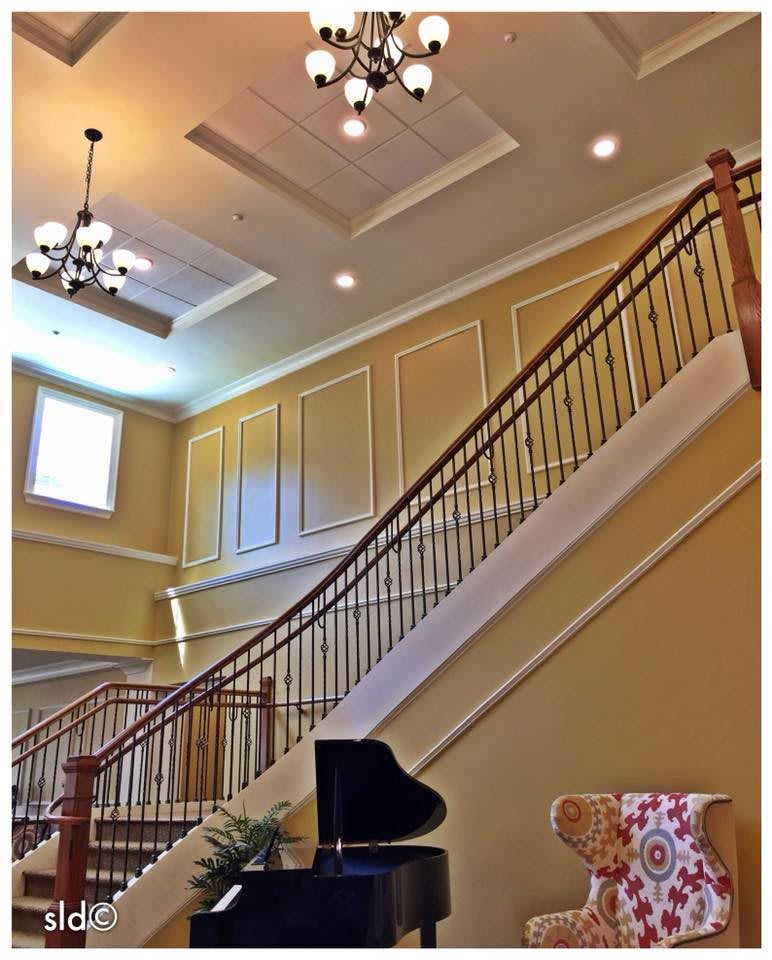 Elegant interior with a grand staircase and chandelier.