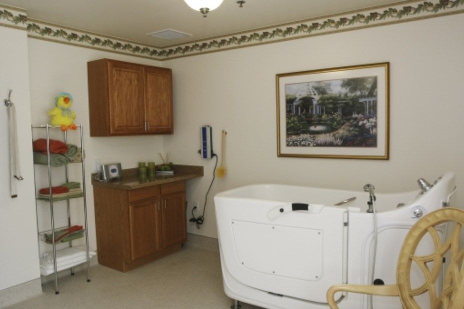 A bathroom featuring a white bathtub, a wooden cabinet, and a decorative painting on the wall.