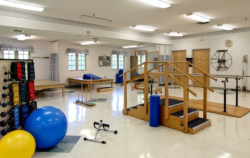 A physical therapy room equipped with exercise equipment and therapy tools.