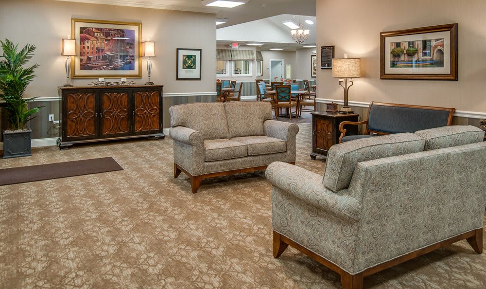 A cozy lobby area featuring sofas, a carpeted floor, and warm lighting.