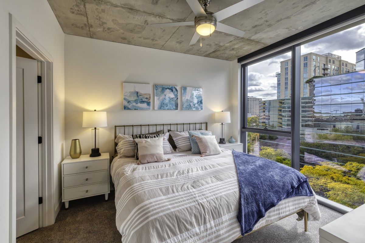 A modern, cozy bedroom with large windows and stylish decor.