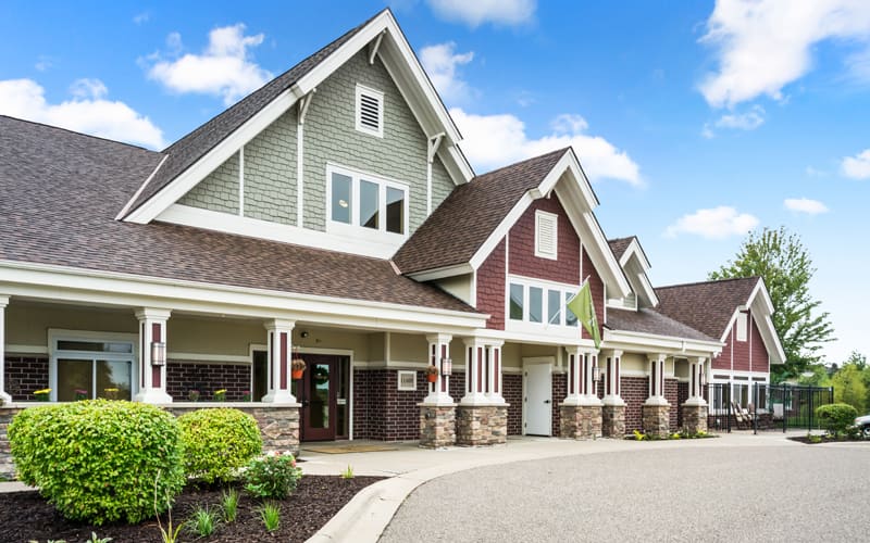A modern suburban house with a large gable roof and stone accents.