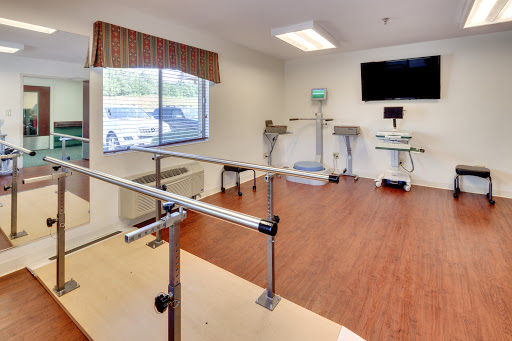A well-equipped physical therapy room featuring parallel bars and various exercise equipment, designed for rehabilitation.