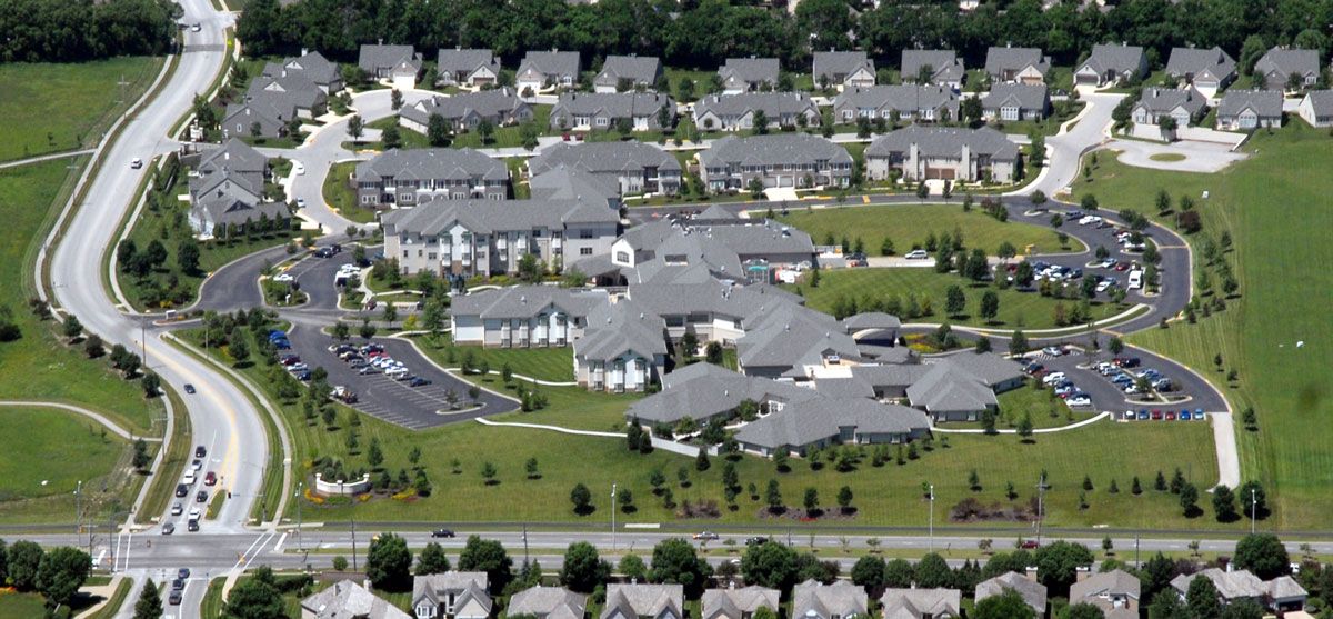 Aerial view of a suburban residential neighborhood with evenly spaced houses and green areas.