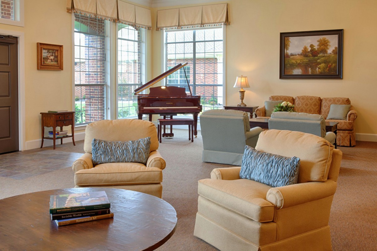 A cozy living room featuring comfortable seating and a grand piano.