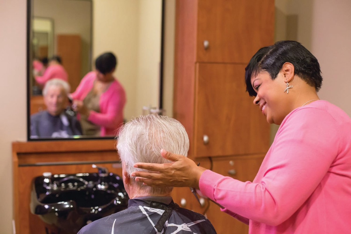A hairstylist giving a haircut to a customer in a salon.