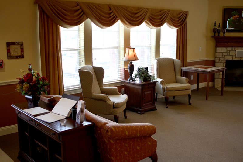 A cozy living room with elegant furniture and large windows adorned with curtains.